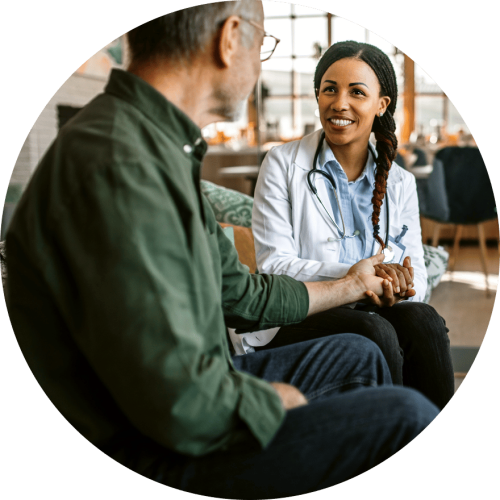 Older gentleman in green short holding hands with female doctor