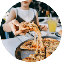 Woman holding very cheesy pizza