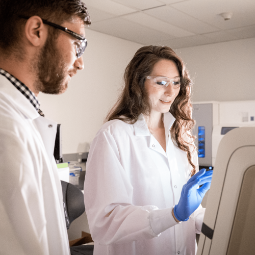 Male and female Arvinas scientific staff looking at monitor